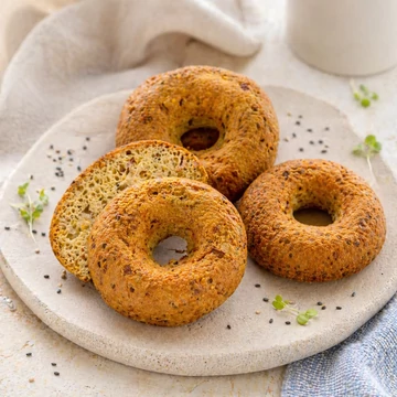 Gluténmentes paleo Bagel aranybarnára sütve, zöldséges bélzettel, kőtálon tálalva