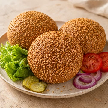 Gluténmentes vegán Hamburgerzsömle szezámmagos felülettel, zöldségekkel tálalva